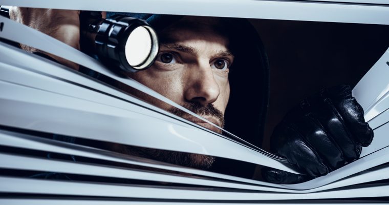 Burglar looking throuth window blinds